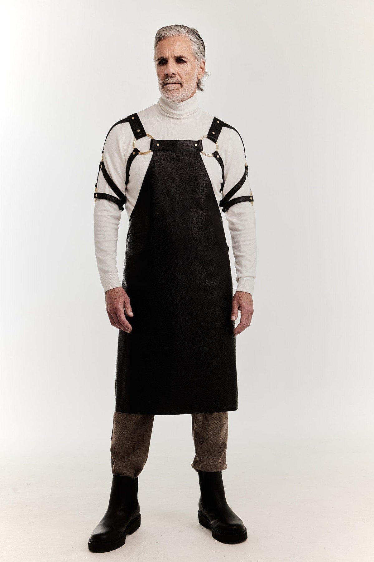 Eskandur men&#39;s black leather luxury premium apron front view grey haired man white shirt gold o-rings on the bust