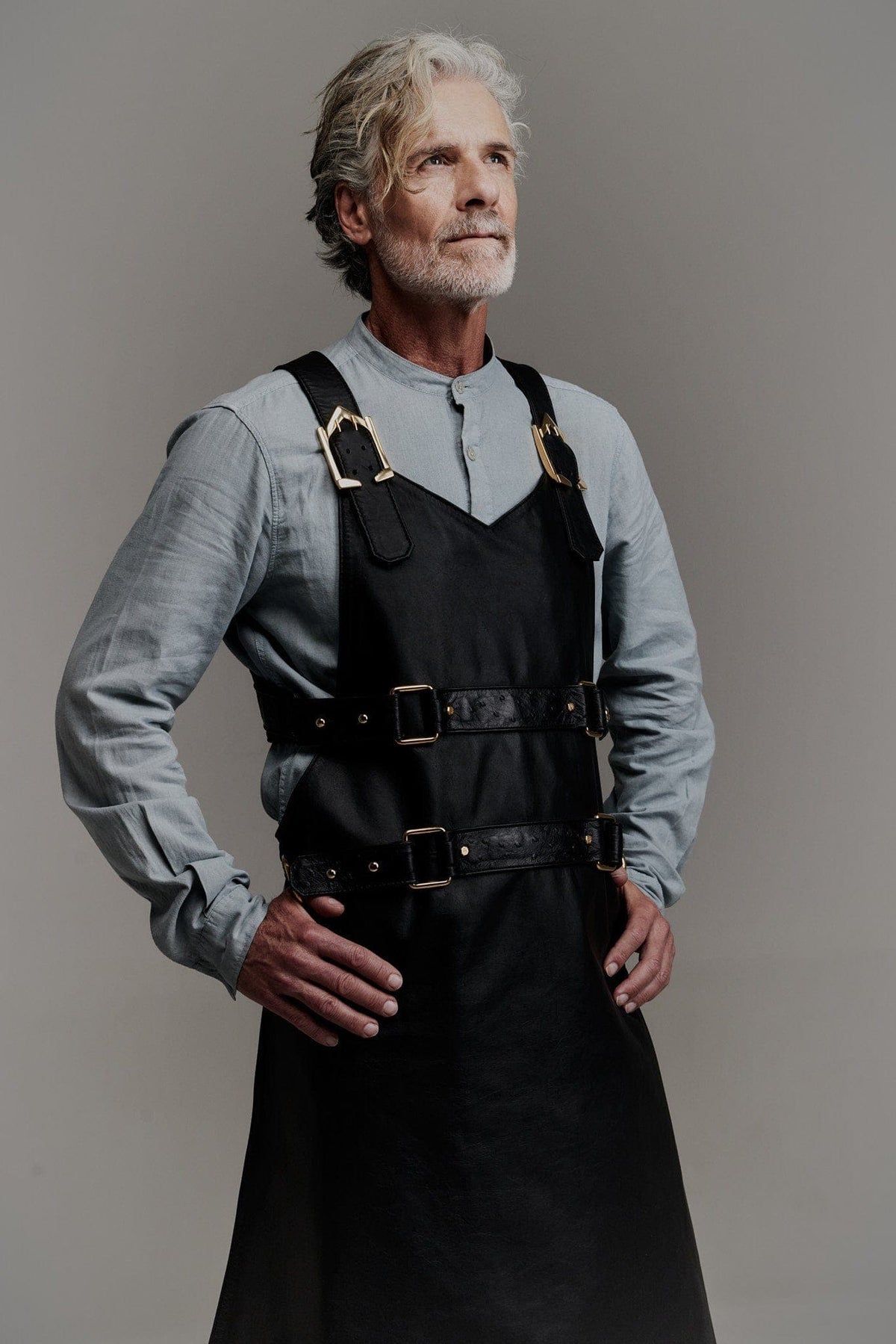 Eskandur men&#39;s black leather luxury apron front view grey haired man with the hands on the hips