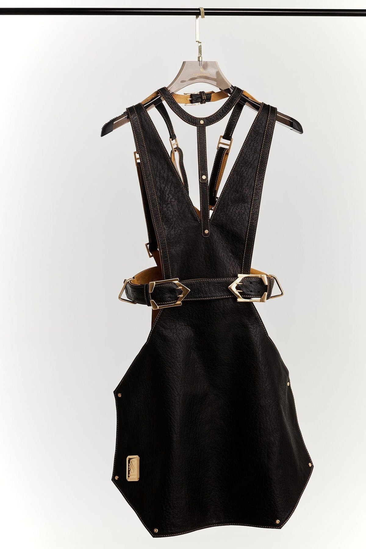 Eskandur women&#39;s black leather luxry premium apron ghost mannequin front view with gold logo plate and gold buckles hanger